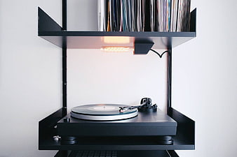 Modern Black Turntable with Vinyl Records on Shelf