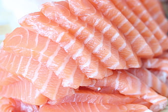 Close-up of fresh salmon sashimi slices with distinct white fat lines
