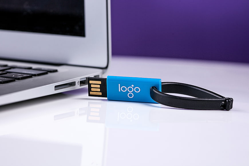 Blue USB Flash Drive With Logo On White Desk