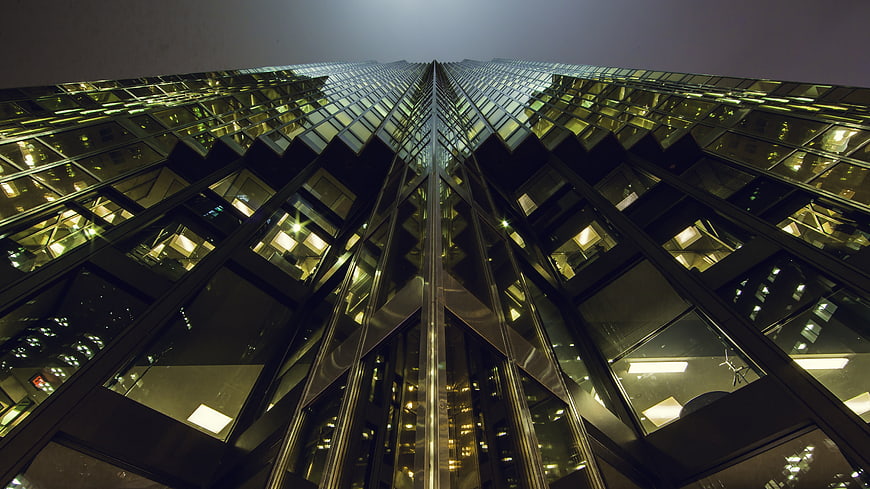 Low angle view of modern glass skyscraper at night