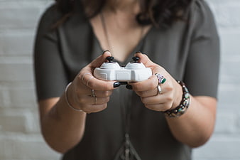 Woman holding white drone controller with black nails