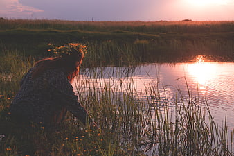Woman with Flower Crown by Lake at Sunset