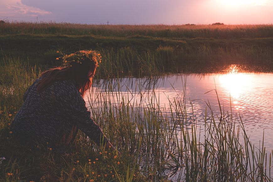 Woman with Flower Crown by Lake at Sunset
