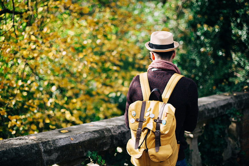 Man with Yellow Backpack and Hat in Autumn Park