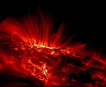 Solar flare eruption with red plasma loops against black space