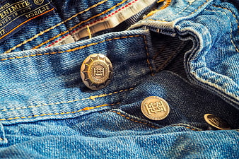 Close-up of vintage denim jeans with brass buttons and stitching