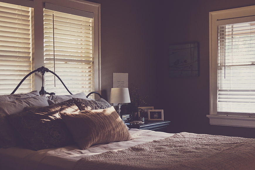 Cozy Bedroom Interior with Sunlight Streaming Through Shutters