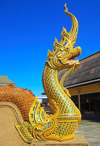 Golden Thai Naga Dragon Sculpture Against Blue Sky