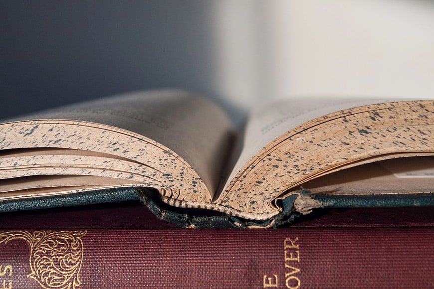Close-up of vintage open book on stack