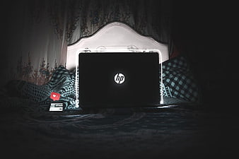 HP Laptop on Bed with Neon Light and Smartphone