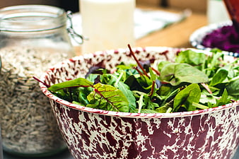 Fresh mixed salad greens in a speckled enamel bowl