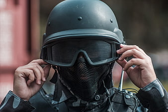 Close-up of soldier adjusting tactical helmet and goggles