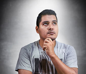 Thoughtful man looking up with hand on chin