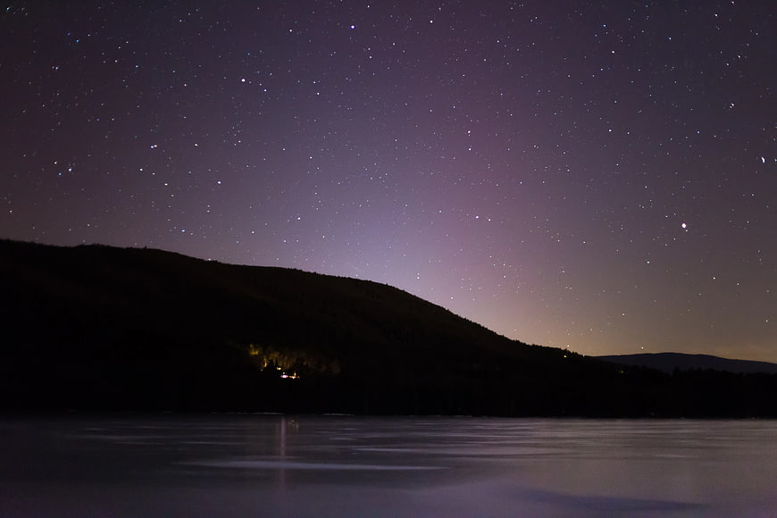 Starry Night Sky Over Silhouette Mountain and Lake