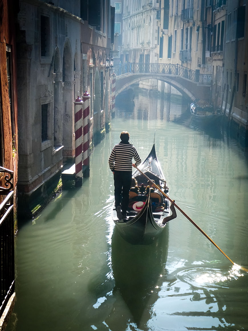 Gondolier rowing through a misty Venice canal