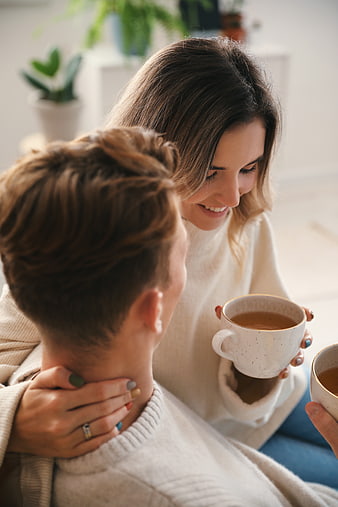 Happy couple drinking coffee and embracing at home