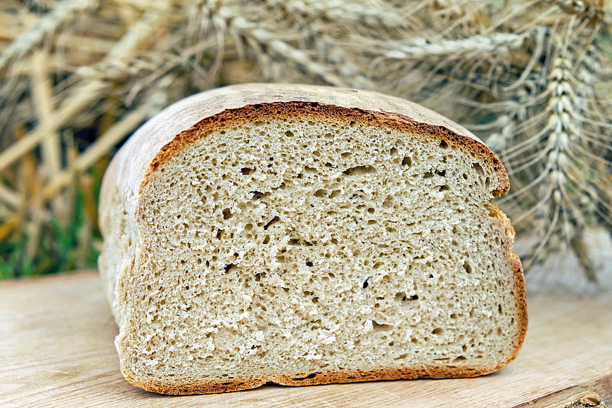 Freshly Baked Artisan Bread Loaf with Wheat Background