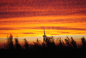 Vibrant Orange Sunset Sky with Silhouette of Cross and Grass