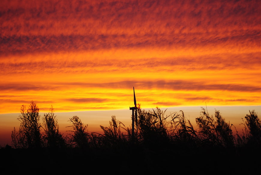 Vibrant Orange Sunset Sky with Silhouette of Cross and Grass