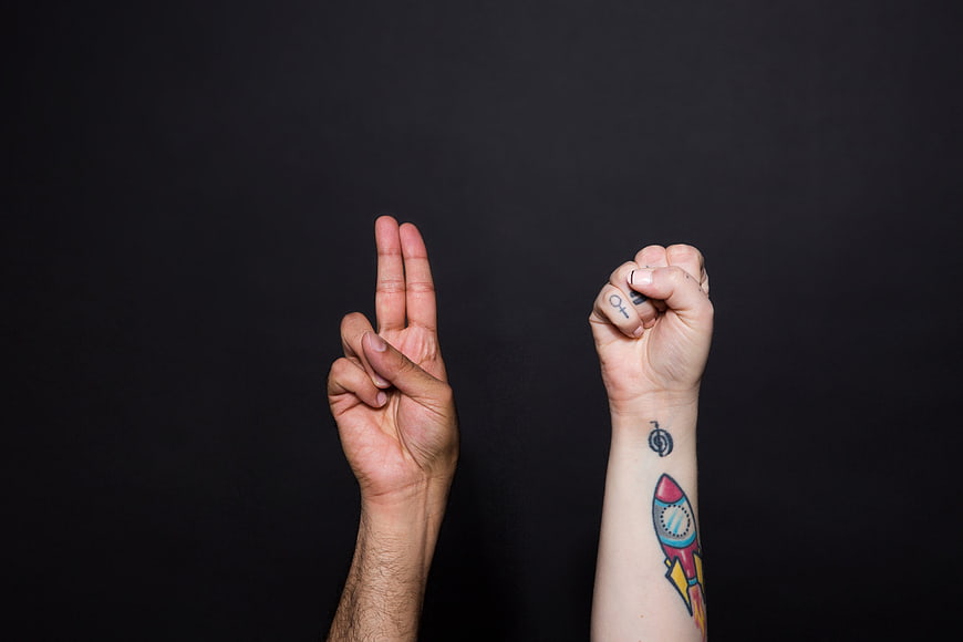 Hands making sign language gestures against black background