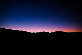 Silhouette of mountain ridge against twilight sky
