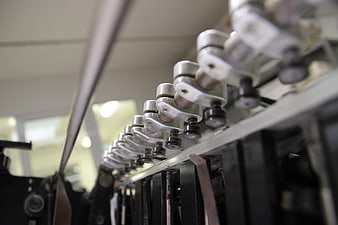 Close-up of industrial printing press grippers and mechanical components