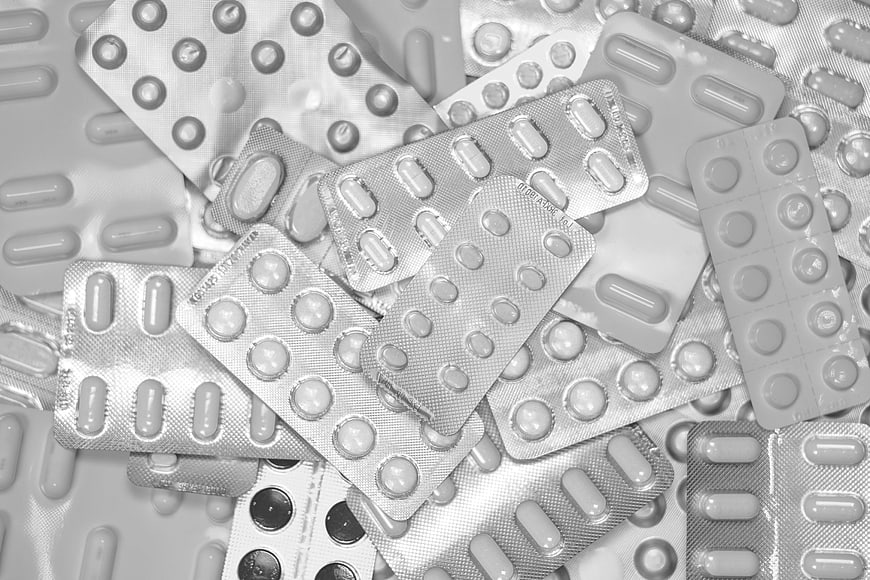 Black and white pile of assorted blister pack medications