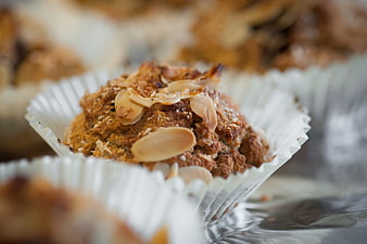 Close-up of almond-topped muffin in white paper liner