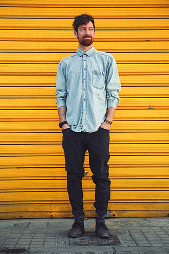 Man in Denim Shirt Standing Against Yellow Wall