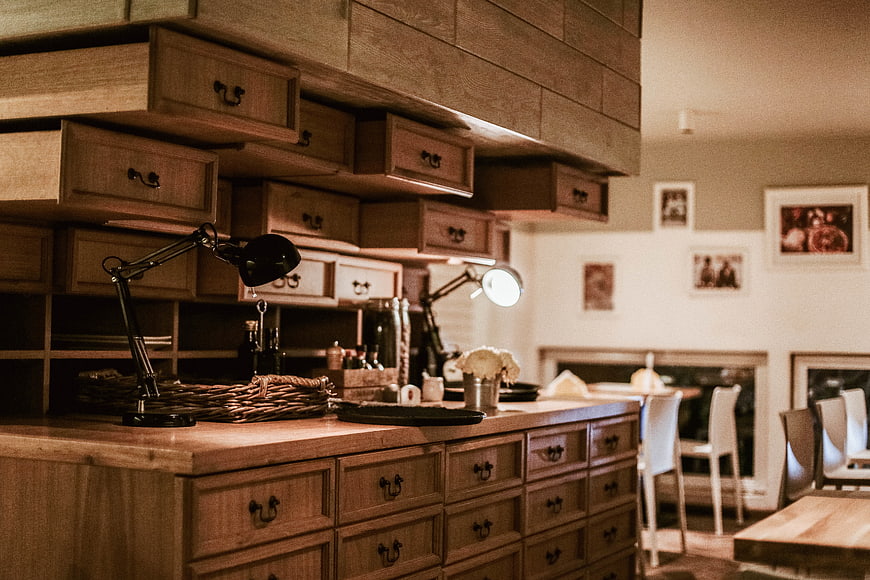 Rustic wooden kitchen island with drawers and desk lamps