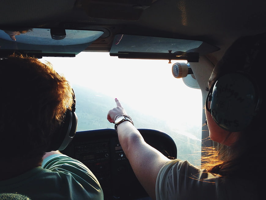 Couple in Airplane Cockpit Pointing at Scenic View