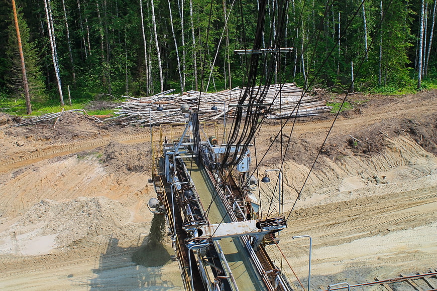 Aerial view of industrial sand mining equipment in a forest clearing
