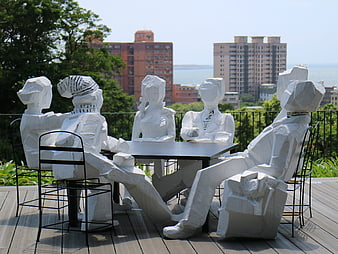 White Sculptural Figures Seated at Table on Rooftop Terrace
