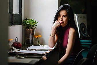 Pensive Asian Woman Sitting at Desk in Office