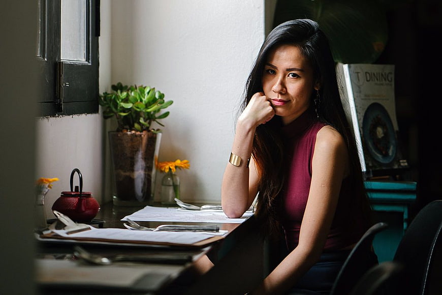Pensive Asian Woman Sitting at Desk in Office