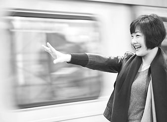 Happy Asian Woman Waving at Passing Train