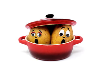 Funny potatoes with googly eyes in red cooking pot