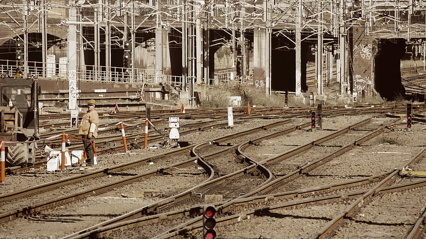 Railway Worker Standing on Complex Train Tracks
