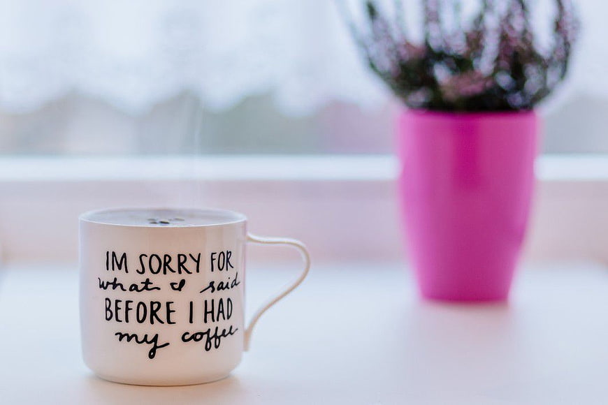 Funny Coffee Mug with Apology Quote on White Table