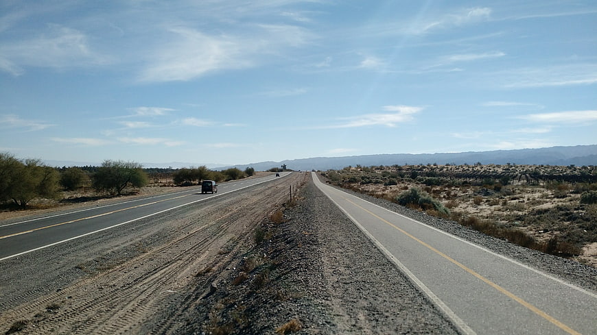 Desert highway with bike path and distant mountains