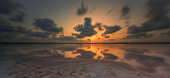 Dramatic Sunset Over Calm Lake With Cloud Reflections