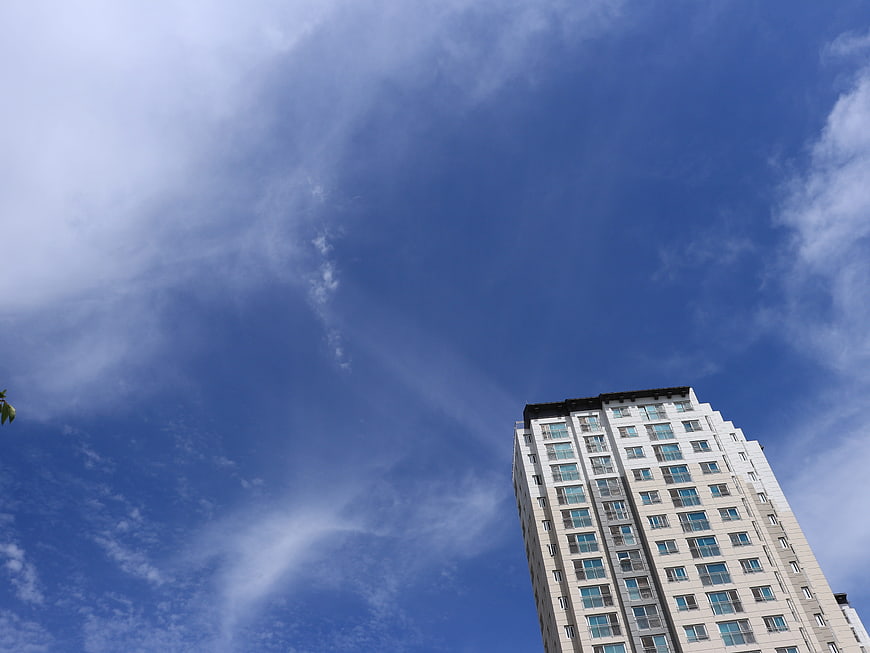 Low angle view of modern skyscraper against blue sky