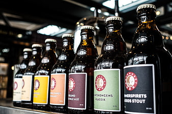 Row of craft beer bottles with colorful labels on shelf