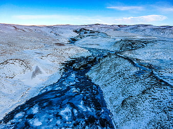 Aerial View of Frozen River in Snowy Winter Landscape
