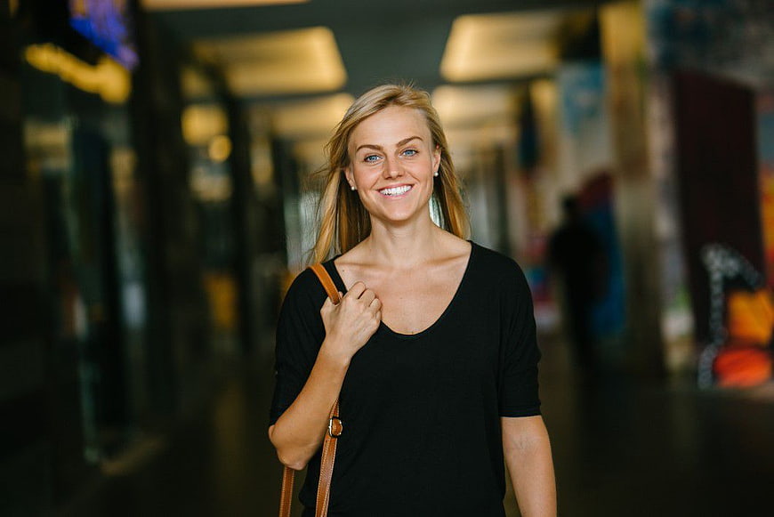 Smiling Blonde Woman Walking in Shopping Mall