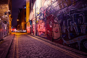 Colorful Graffiti Alley at Night on Cobblestone Street