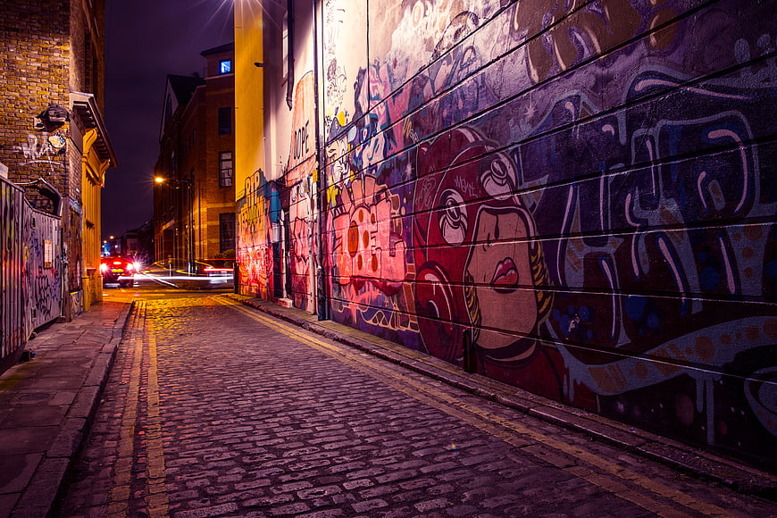 Colorful Graffiti Alley at Night on Cobblestone Street