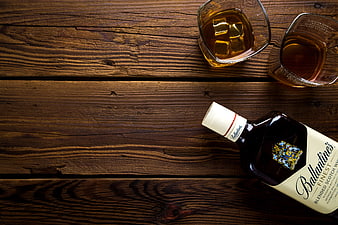 Ballantine's Whisky Bottle and Glasses on Wooden Table