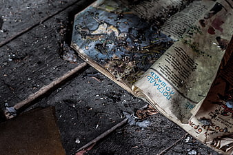 Burnt old book on charred wooden floor