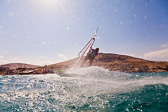Windsurfer carving through waves on sunny day